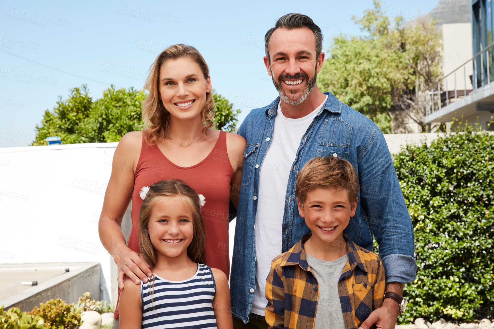 Buy stock photo Portrait of a happy young family spending quality time in their backyard at home