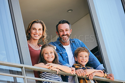 Buy stock photo Portrait of a happy young family standing on the balcony of their home