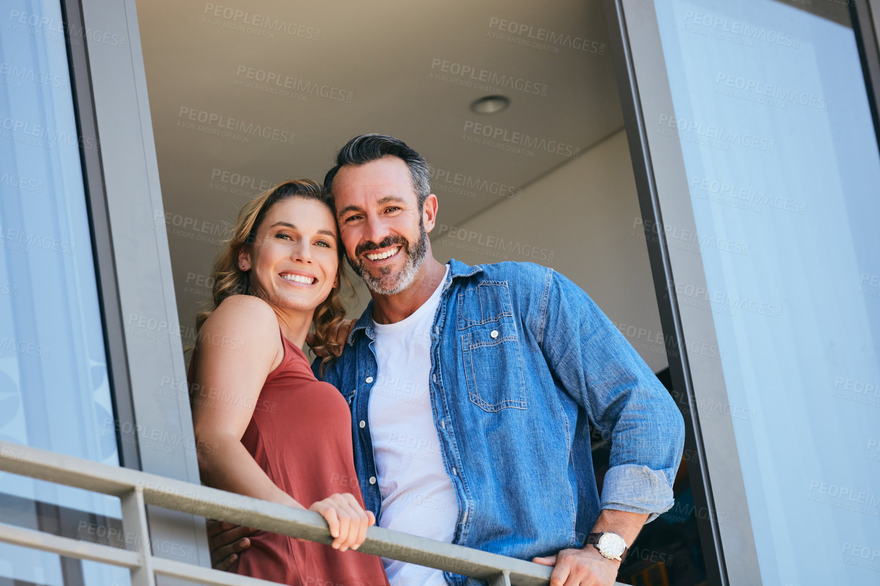 Buy stock photo Portrait of a happy couple standing on the balcony of their home