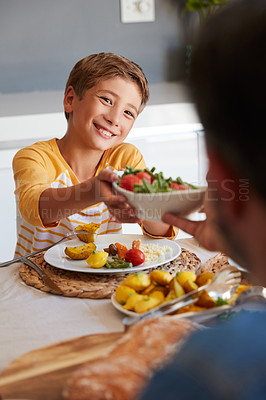 Buy stock photo Shot of an adorable little boy having a meal with his family at home