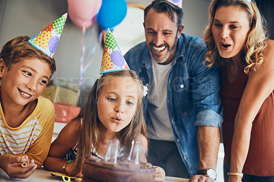 Buy stock photo Shot of an adorable little girl celebrating her birthday with her family at home