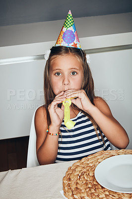 Buy stock photo Shot of an adorable little girl blowing a party horn at a birthday party
