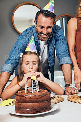 Buy stock photo Shot of an adorable little girl celebrating her birthday with her family at home