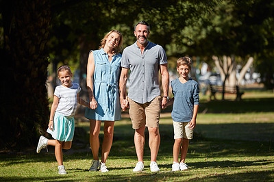 Buy stock photo Shot of a happy young family going for a walk in the park