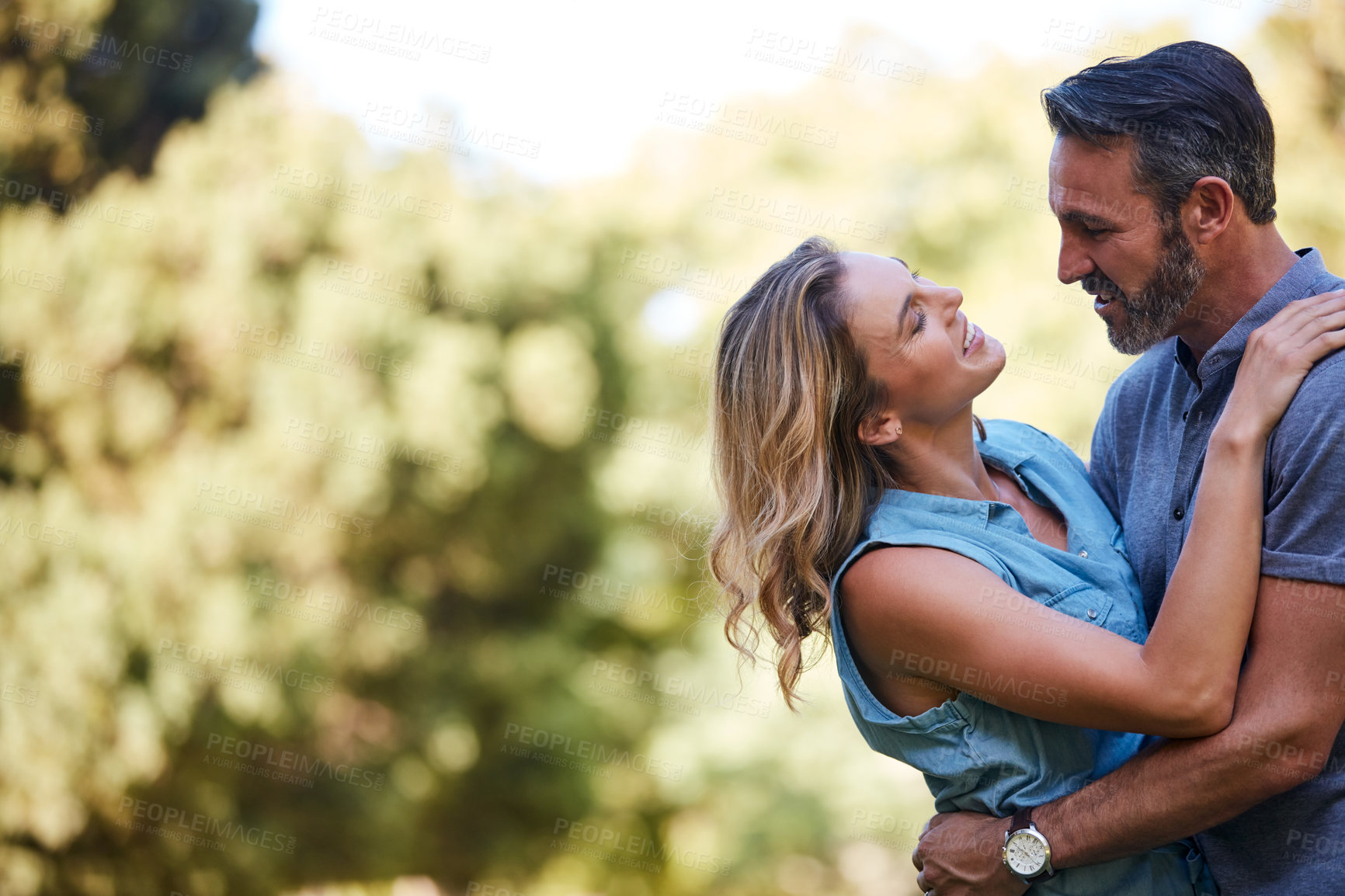 Buy stock photo Shot of a happy couple embracing in the park