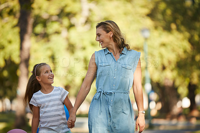 Buy stock photo Shot of an adorable little girl going for a walk in the park with her mother