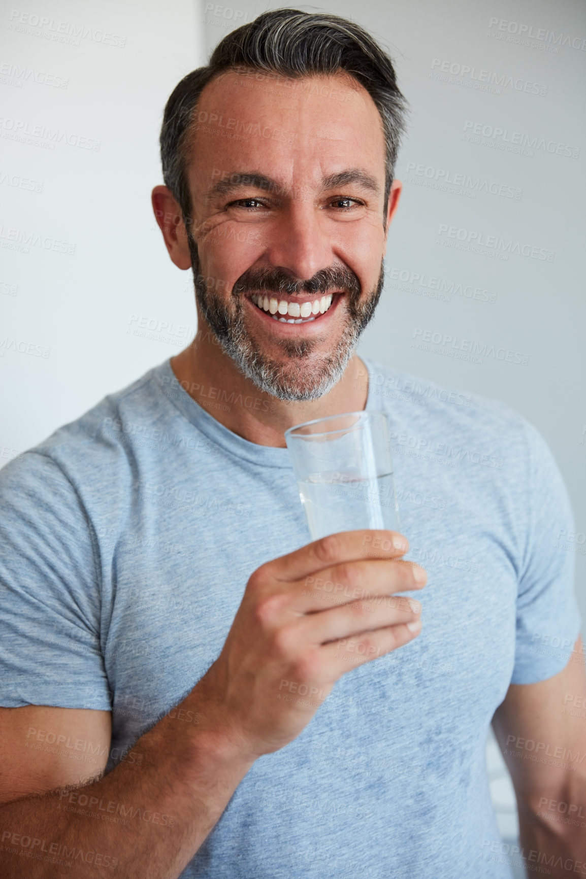 Buy stock photo Cropped portrait of a mature man holding a glass of water at home in the morning