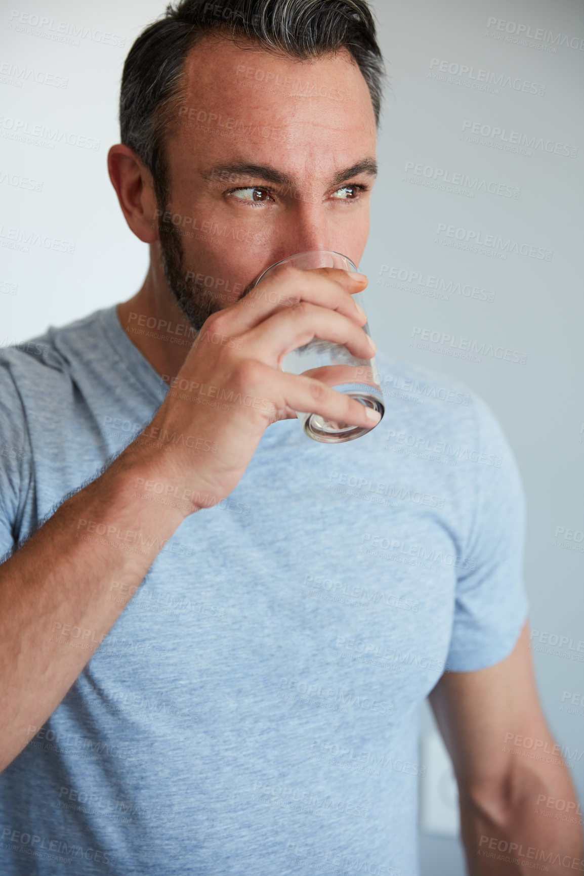 Buy stock photo Cropped shot of a middle aged man drinking a glass of water at home in the morning