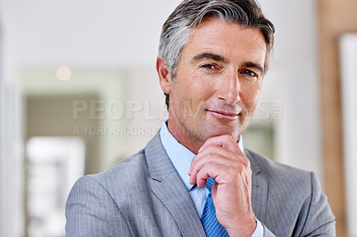Buy stock photo Headshot of a confident mature man wearing a suit and standing indoors with his hand raised to his chin