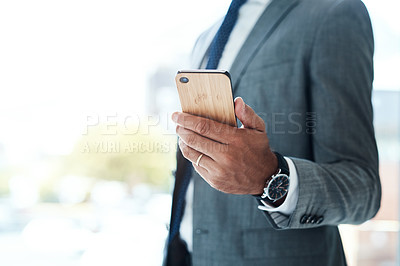 Buy stock photo Cropped shot of an unrecognizable businessman using his cellphone