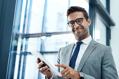 Buy stock photo Shot of a professional businessman using a digital tablet in his office