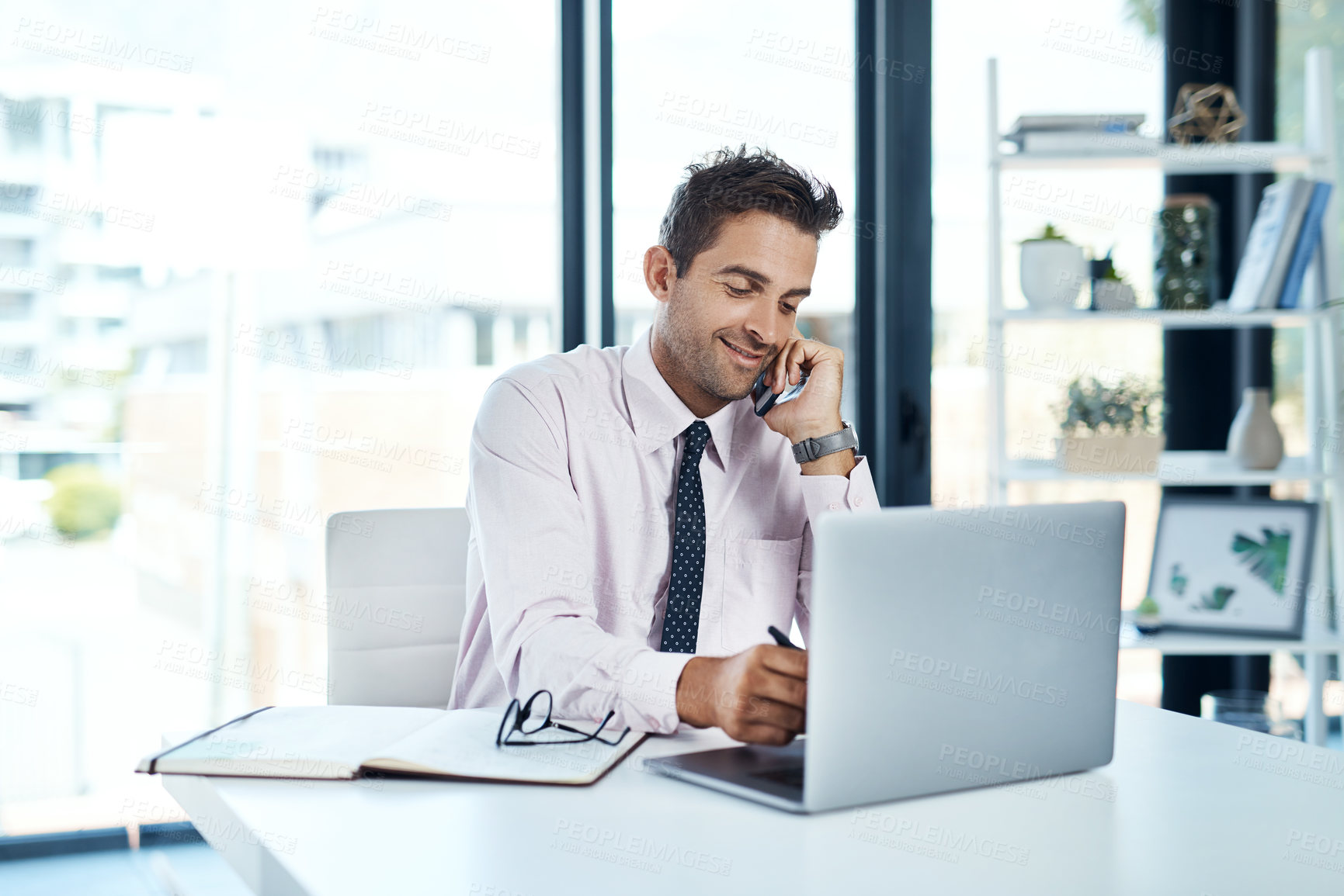 Buy stock photo Laptop, phone call and writing with financial advisor man in office for communication or trading. Computer, conversation and notebook with happy broker in professional workplace for portfolio growth