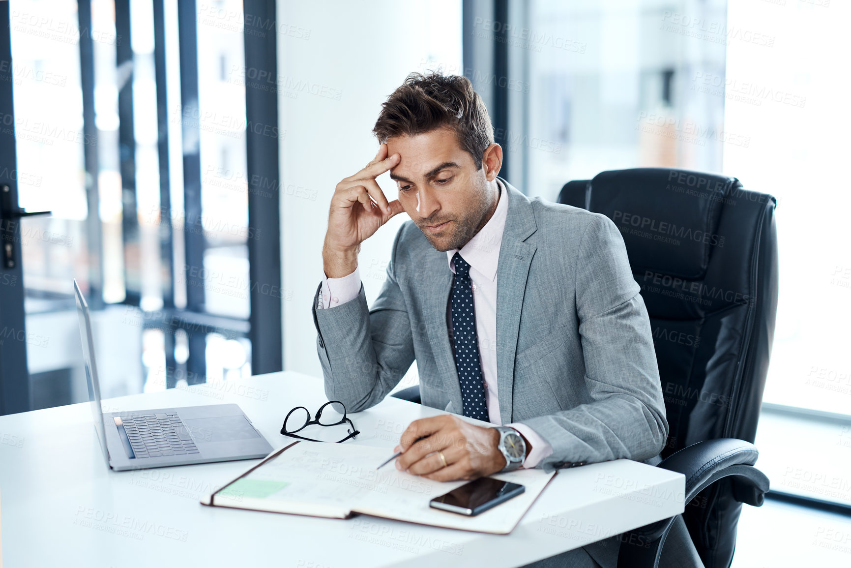 Buy stock photo Cropped shot of a businessman looking stressed while sitting at his desk