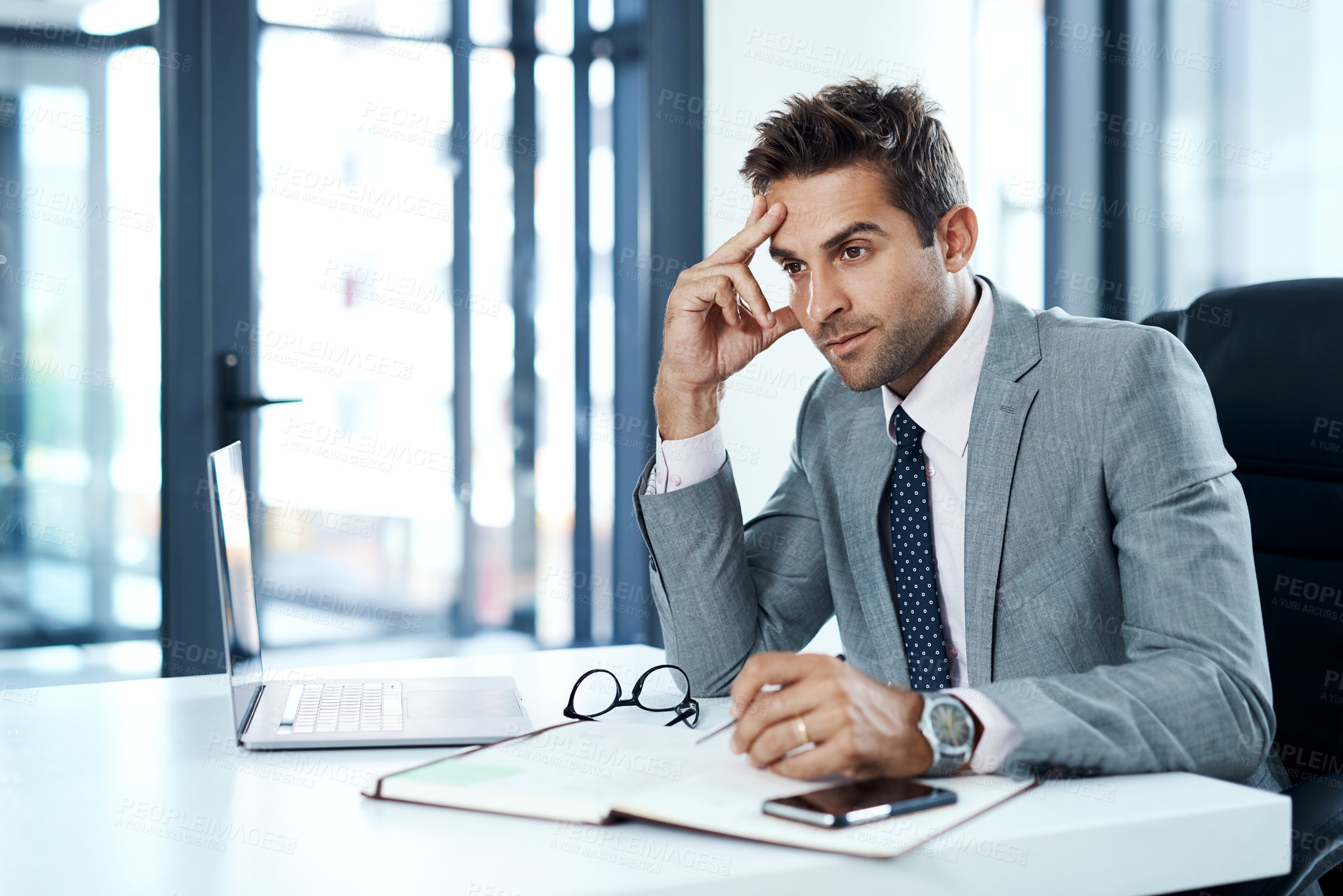 Buy stock photo Cropped shot of a businessman looking stressed while sitting at his desk