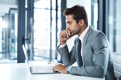 Buy stock photo Shot of a professional businessman sitting at his desk