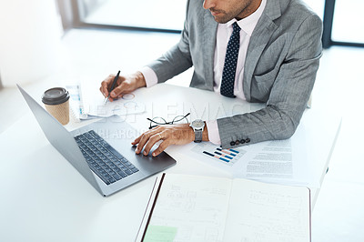 Buy stock photo Cropped shot of a businessman working with paperwork and his laptop