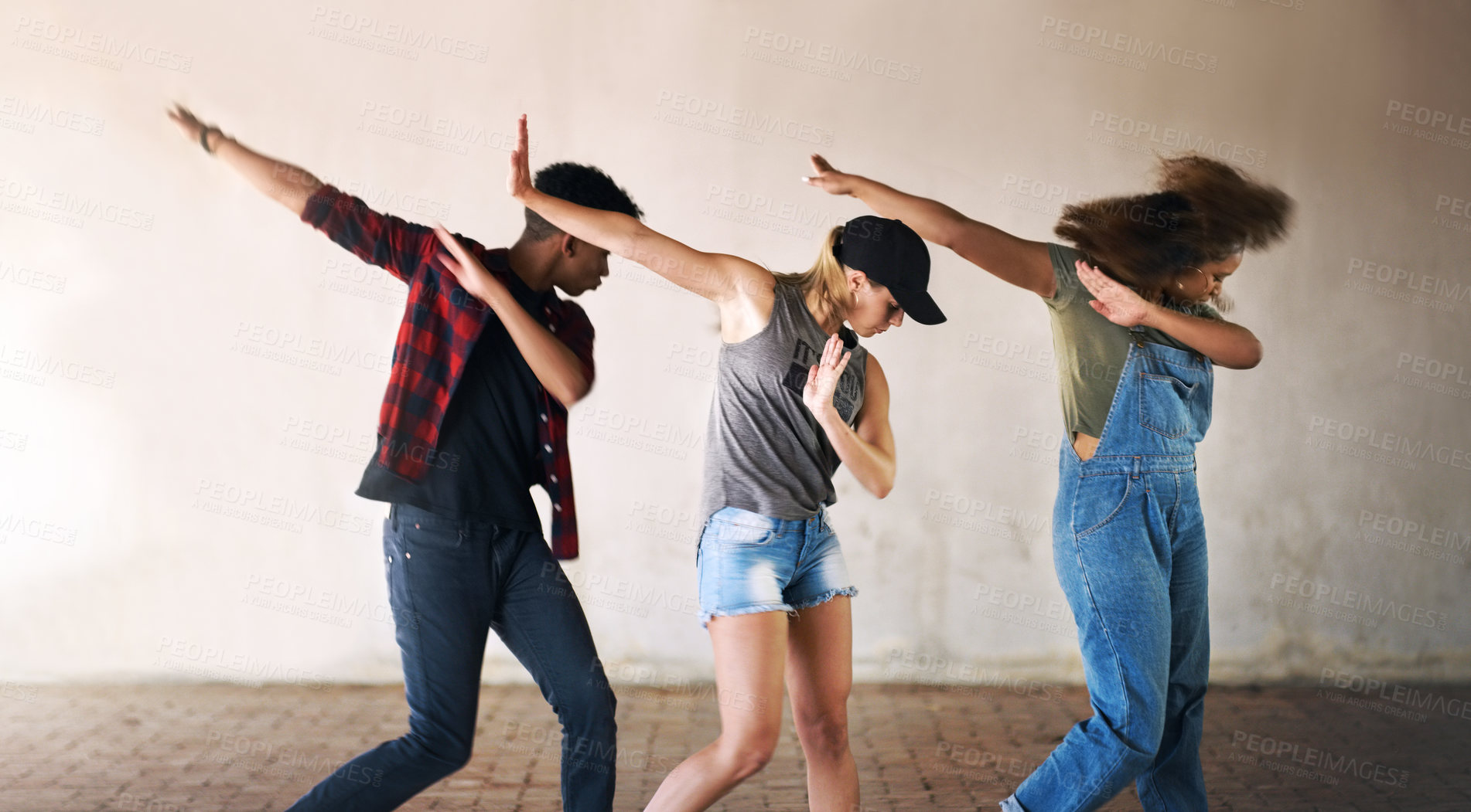 Buy stock photo Cropped shot of a young diverse group of dancers performing a routine against a walled background outdoors