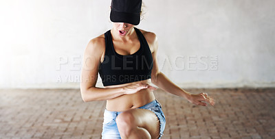 Buy stock photo Cropped shot of an attractive young woman performing a dance routine against a walled background outdoors