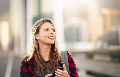 Buy stock photo Cropped shot of an attractive young woman standing outdoors and looking away while using her cellphone