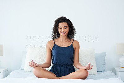 Buy stock photo Shot of an attractive young woman sitting and meditating on her bed in the morning
