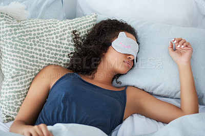 Buy stock photo Shot of an attractive young woman sleeping in bed with an eye mask during the morning