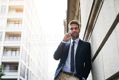 Buy stock photo Portrait of a handsome young businessman talking on his cellphone while heading to work in the morning