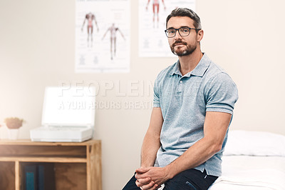 Buy stock photo Portrait of a handsome mature male physiotherapist sitting in his office