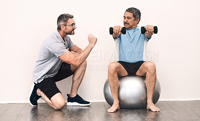 Buy stock photo Full length shot of a senior man exercising with dumbbells during a rehabilitation session with his physiotherapist
