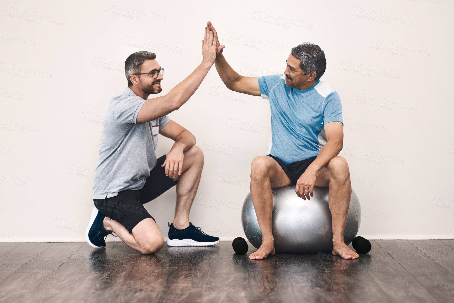 Buy stock photo Full length shot of a senior man getting a high five from his physiotherapist during a rehabilitation session