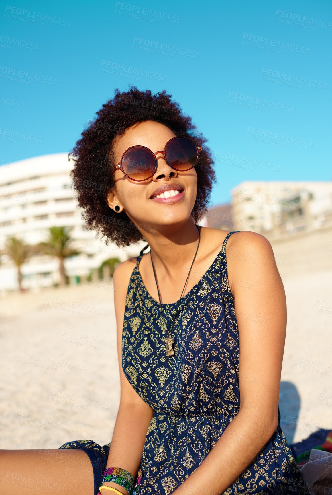 Buy stock photo Cropped shot of an attractive young woman wearing casual clothes while sitting on the beach alone and enjoying the sunshine