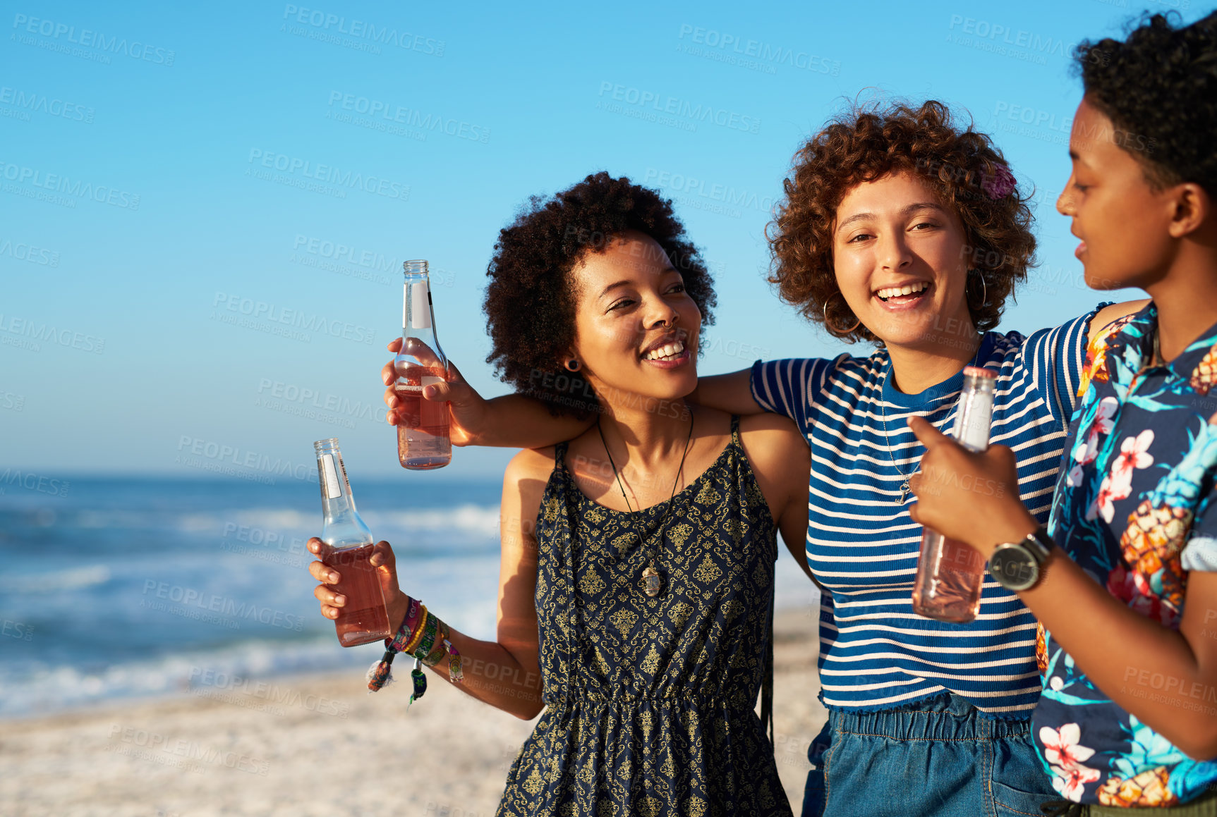 Buy stock photo Shot of an attractive young trio of women enjoying a day out together on the beach during the day