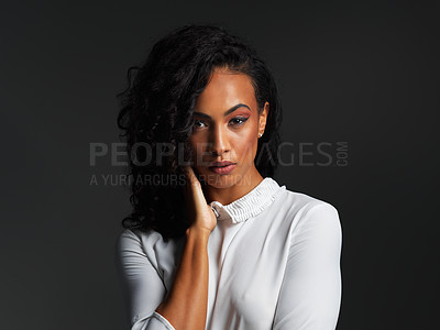 Buy stock photo Portrait of an attractive young woman wearing a white blouse and posing alone against a dark background in the studio