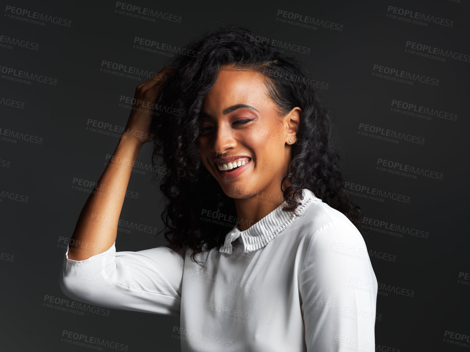 Buy stock photo Studio shot of an attractive young woman wearing a white blouse and smiling against a dark background