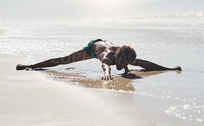 Buy stock photo Full length shot of a handsome young man performing a side split while dancing on the beach during the day