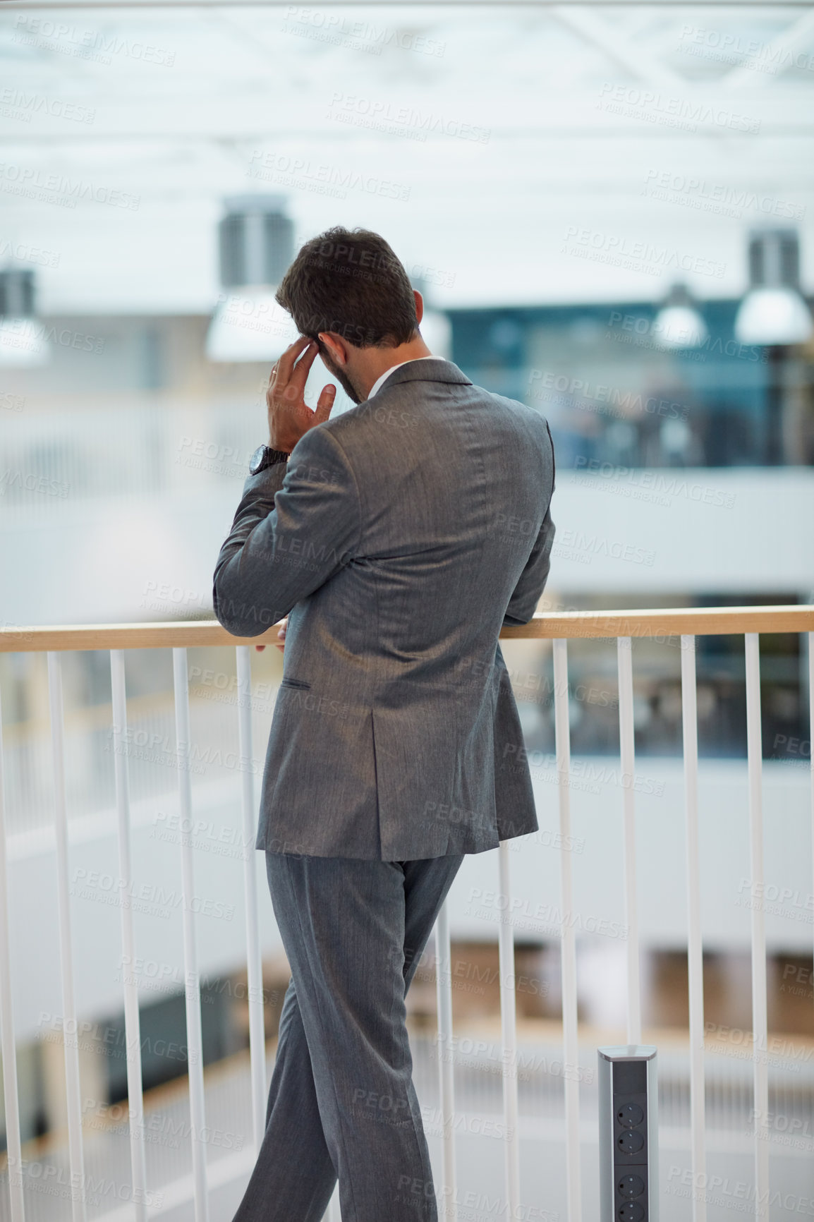 Buy stock photo Rearview shot of a young businessman looking stressed out while standing in an office