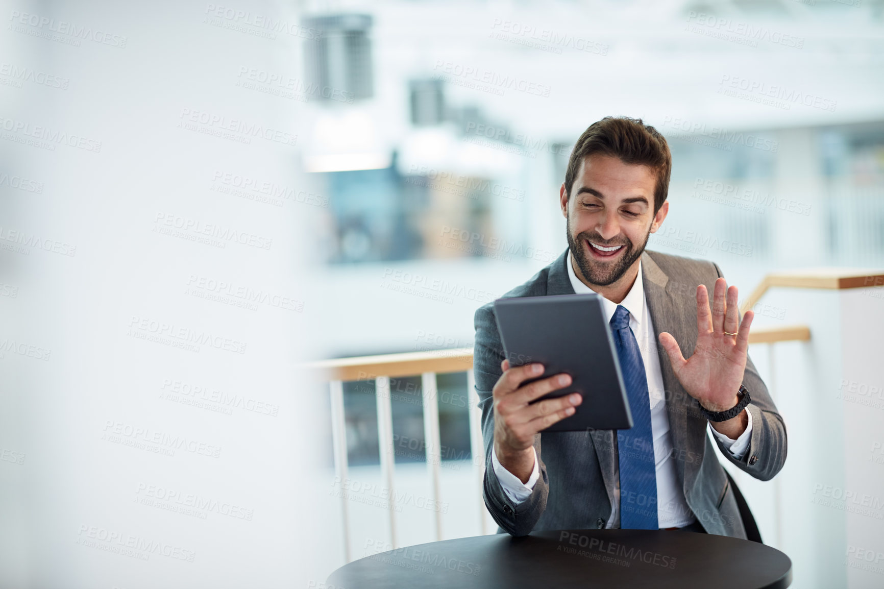 Buy stock photo Shot of a young businessman making a video call on a digital tablet in an office