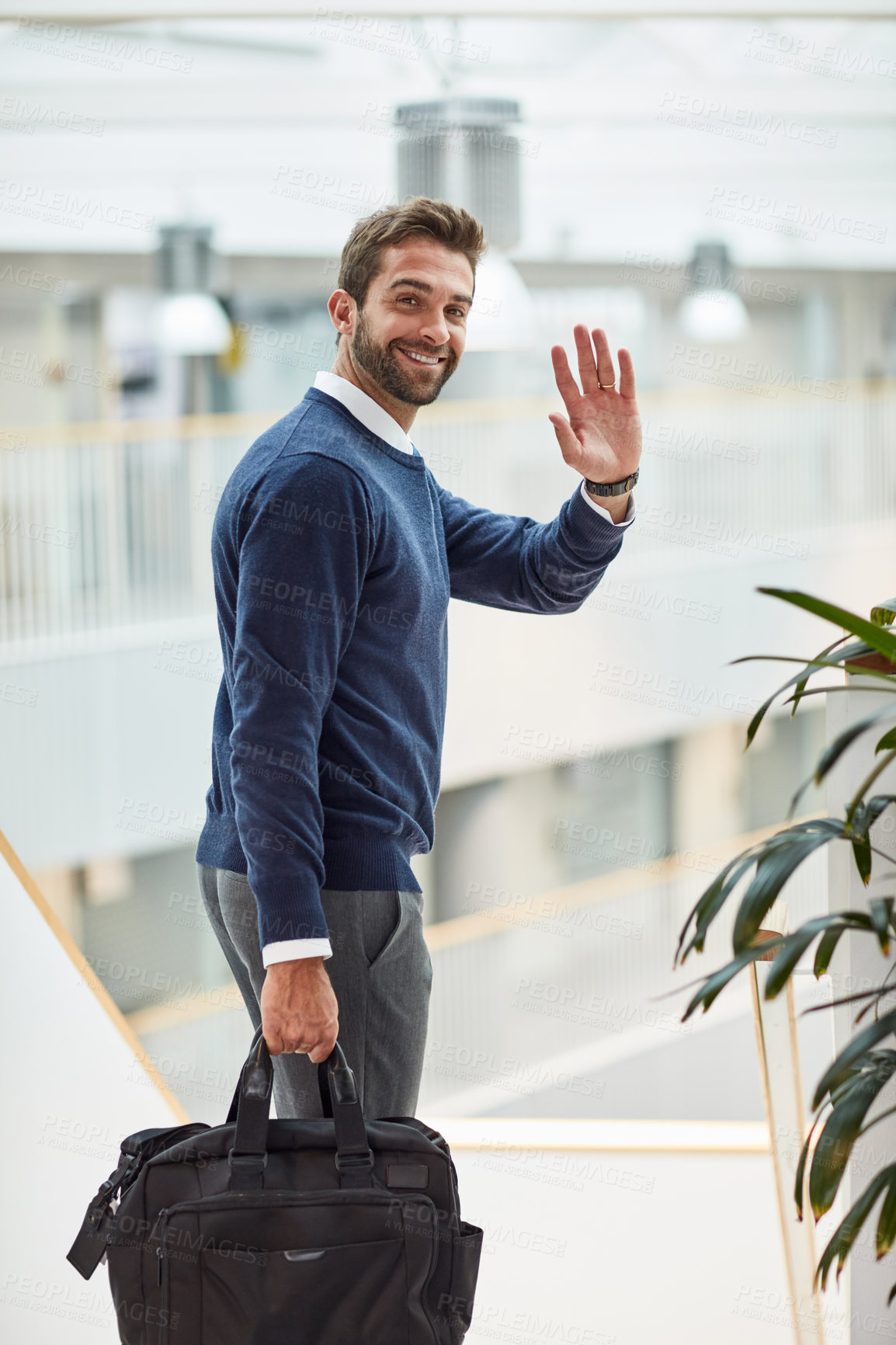 Buy stock photo Portrait of a young businessman waving while carrying a bag