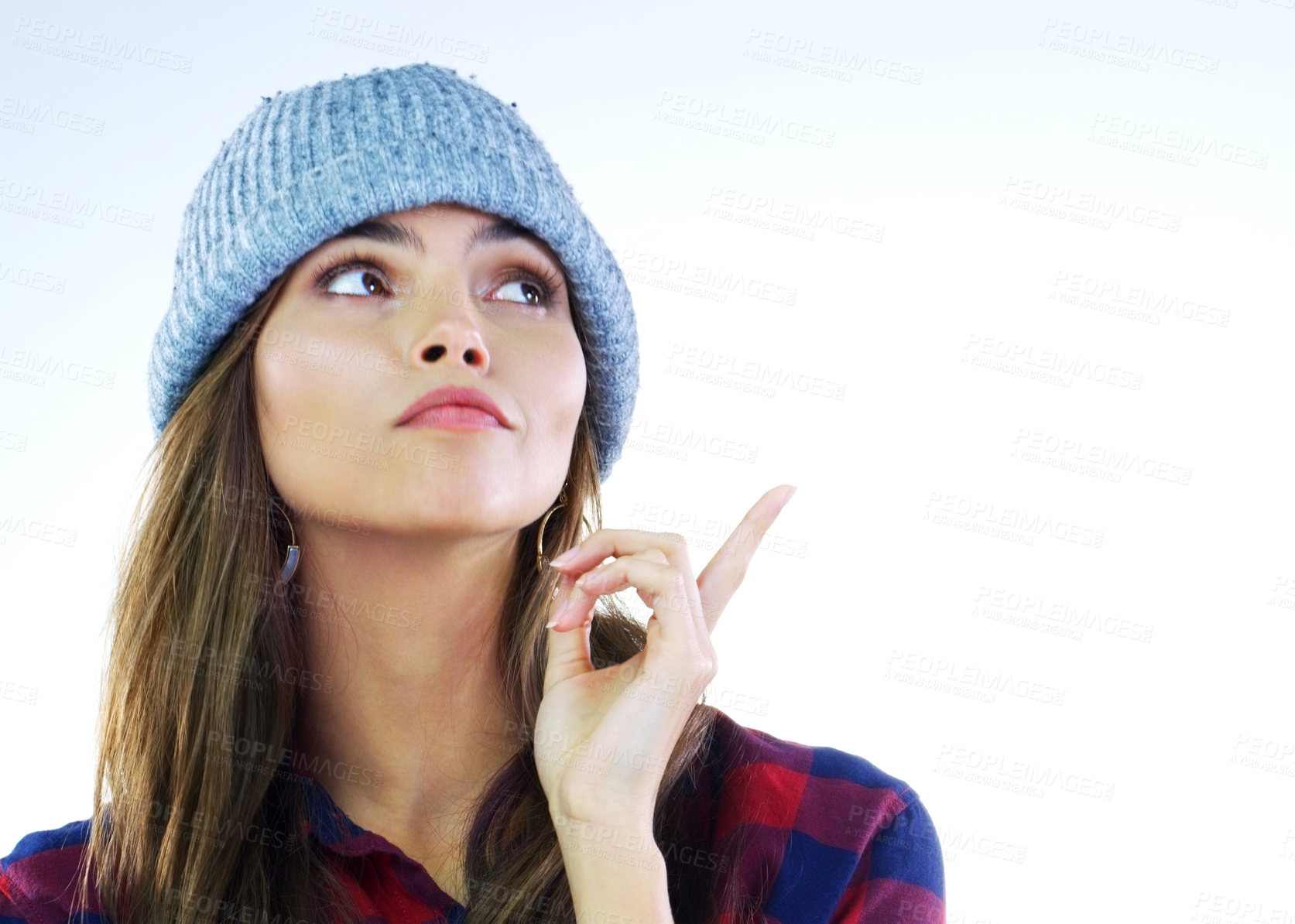 Buy stock photo Cropped shot of a young woman pointing at something against a white background