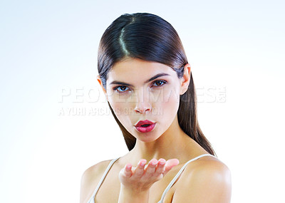 Buy stock photo Cropped shot of a beautiful young woman blowing kisses against a white background