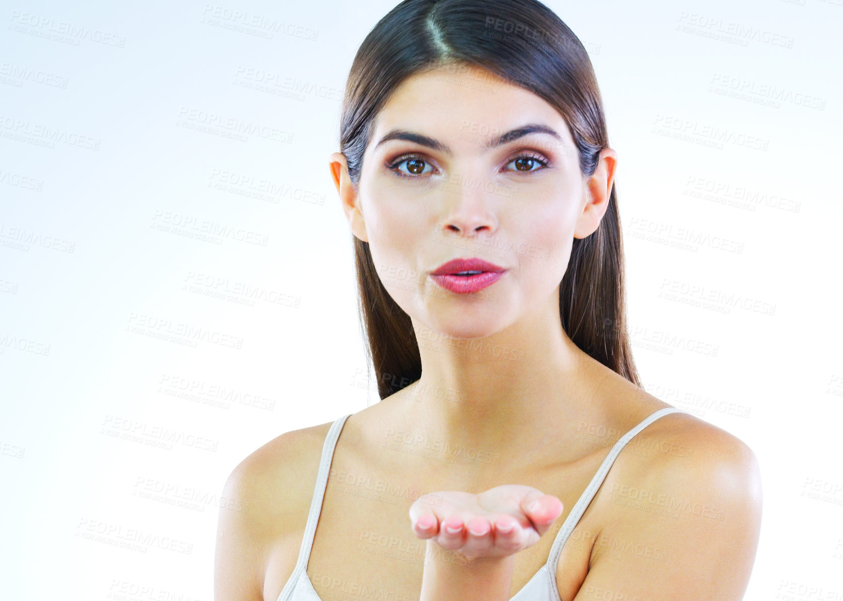 Buy stock photo Cropped shot of a beautiful young woman blowing kisses against a white background