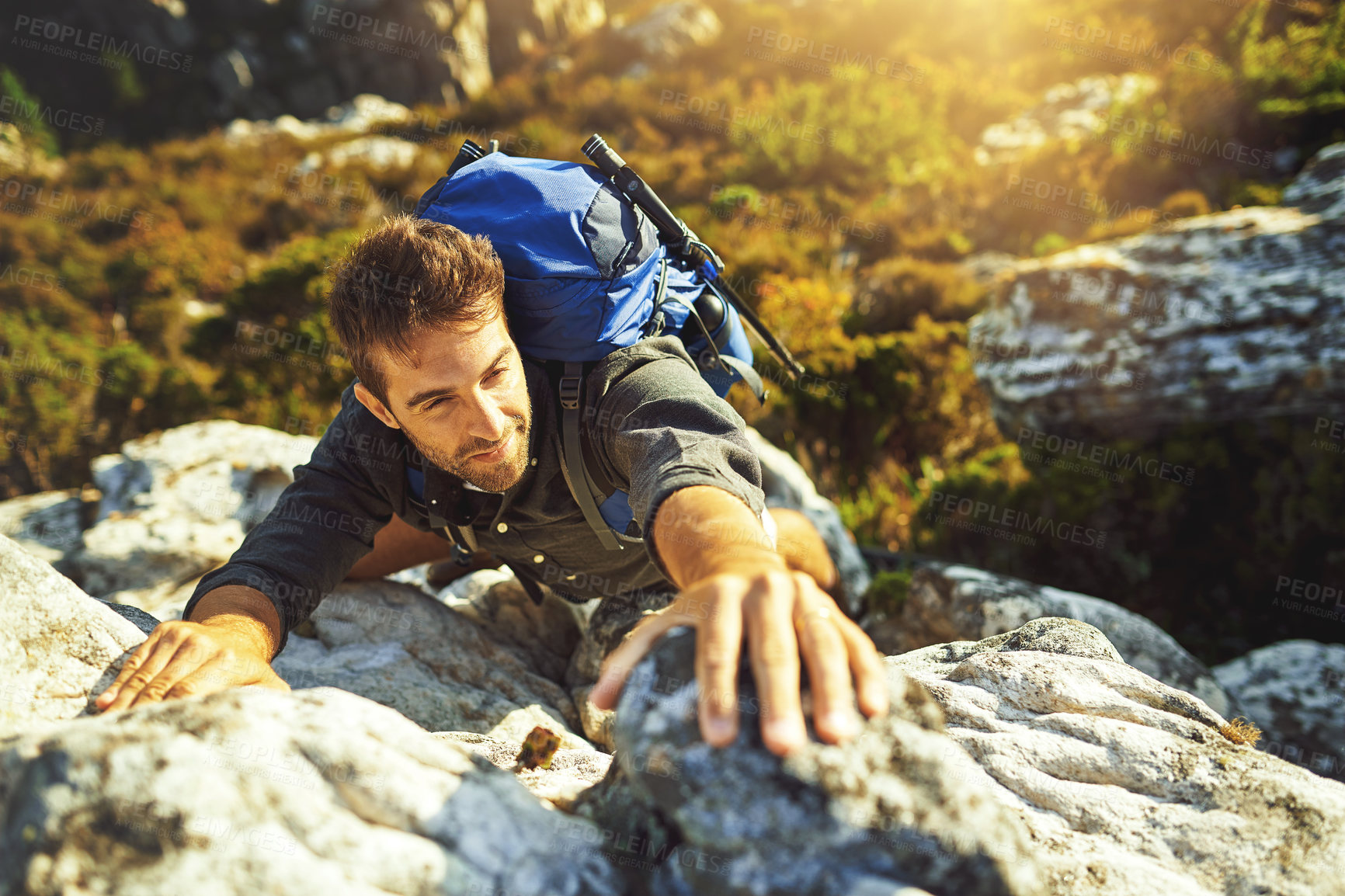 Buy stock photo Man, rocks and climbing on mountain outdoor of fitness adventure, sport challenge and hiking travel. Male person, backpack and support for trekking, balance and exercise performance of nature explore