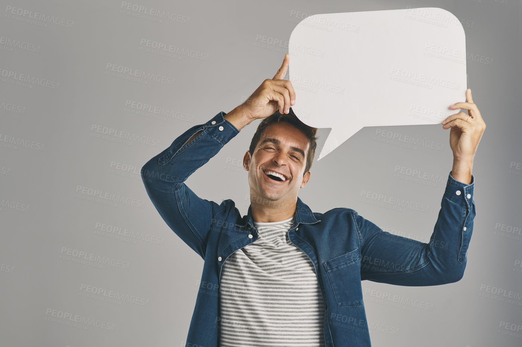 Buy stock photo Speech bubble, man and communication with poster, funny and guy on gray studio background. Person, mockup space and model with presentation, laughing or blank billboard with branding placard or humor