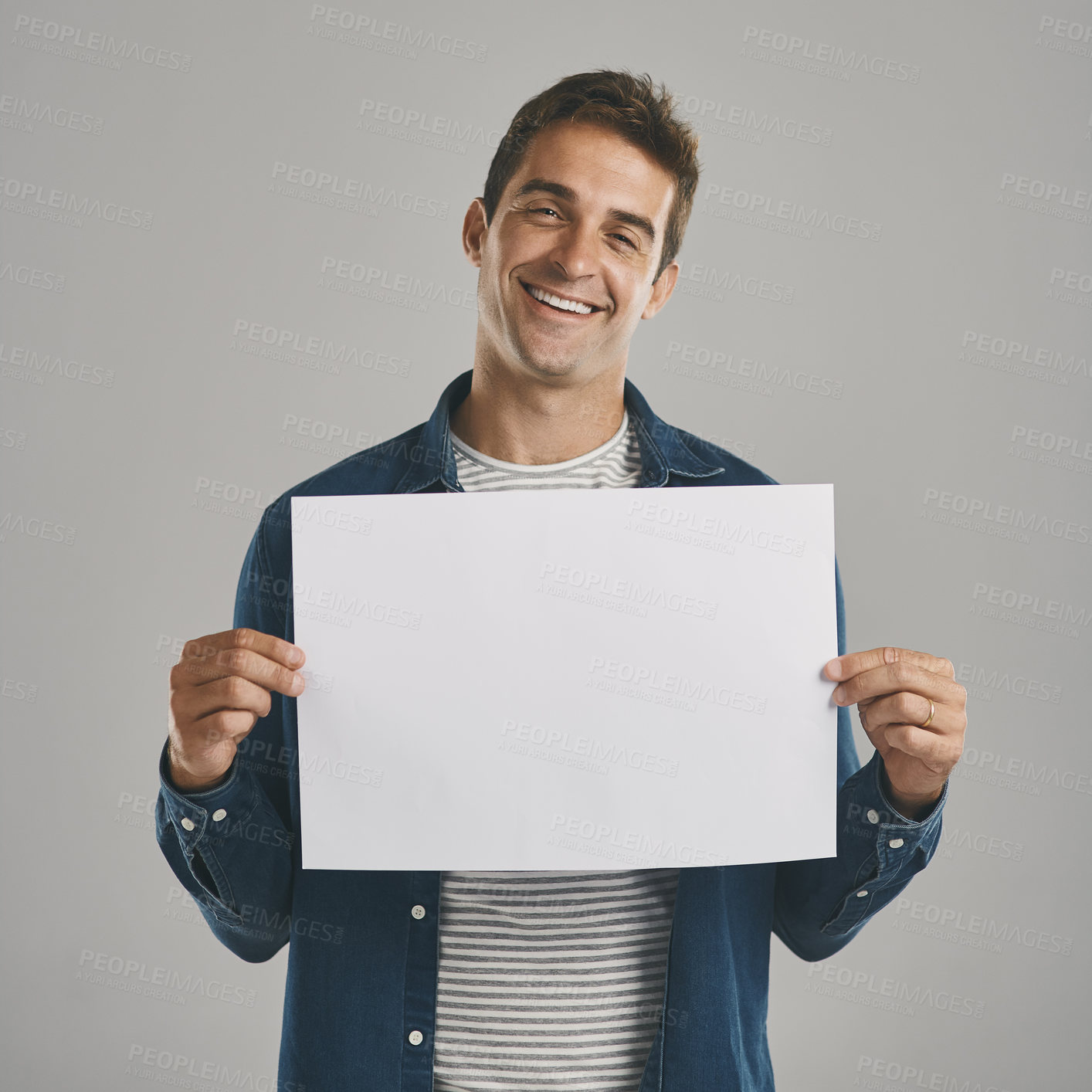 Buy stock photo Studio portrait of a young man holding a blank placard against a grey background