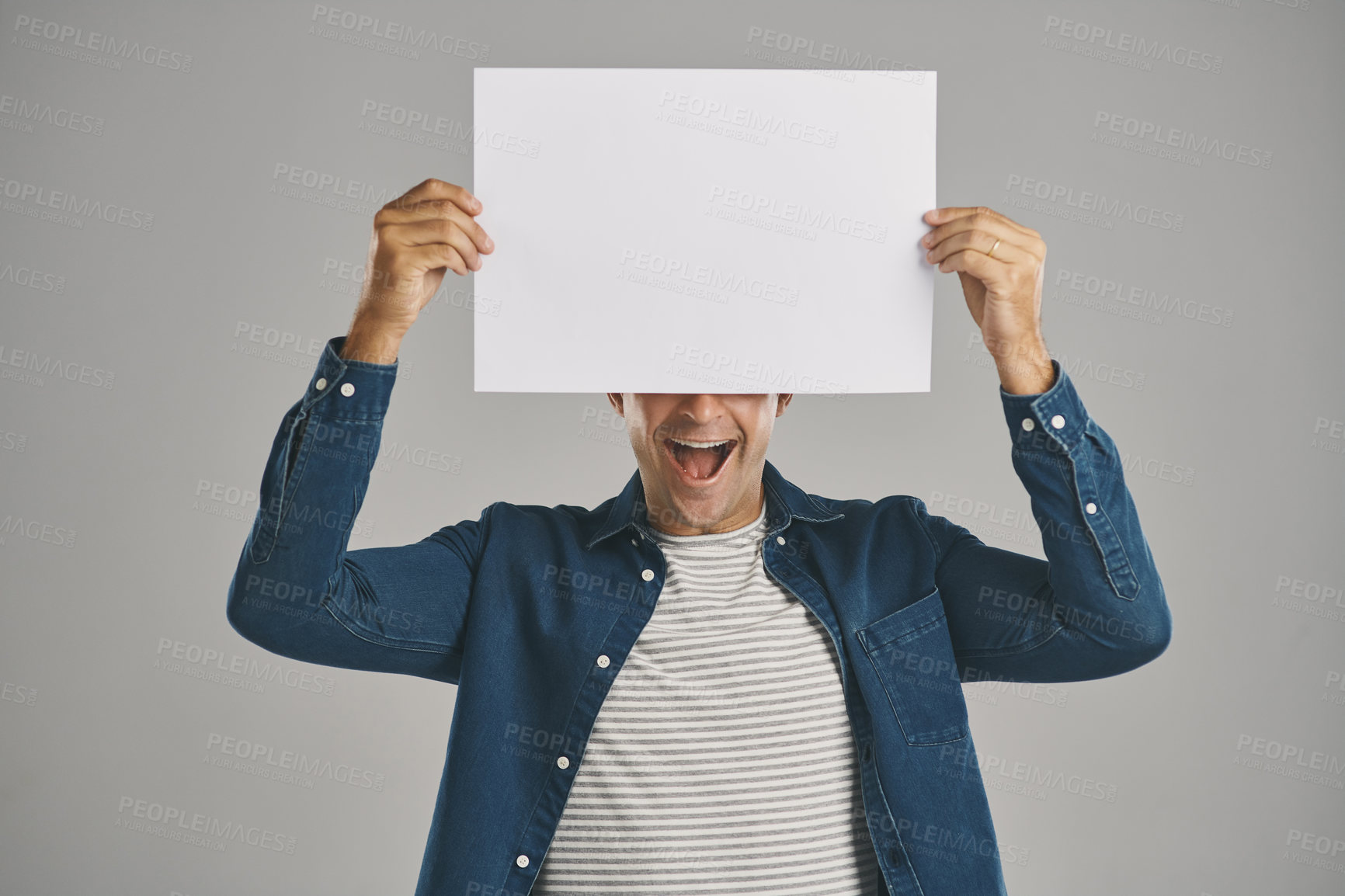 Buy stock photo Happy, blank and placard with man in studio for billboard announcement, presentation and branding logo. Male person, paper and advertising for news poster, signage and notification on gray background