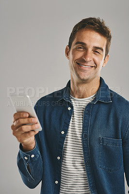 Buy stock photo Portrait, man and happy with smartphone in studio for social media, post or entertainment on white background. Male person, smile and satisfied with internet or online for communication or networking