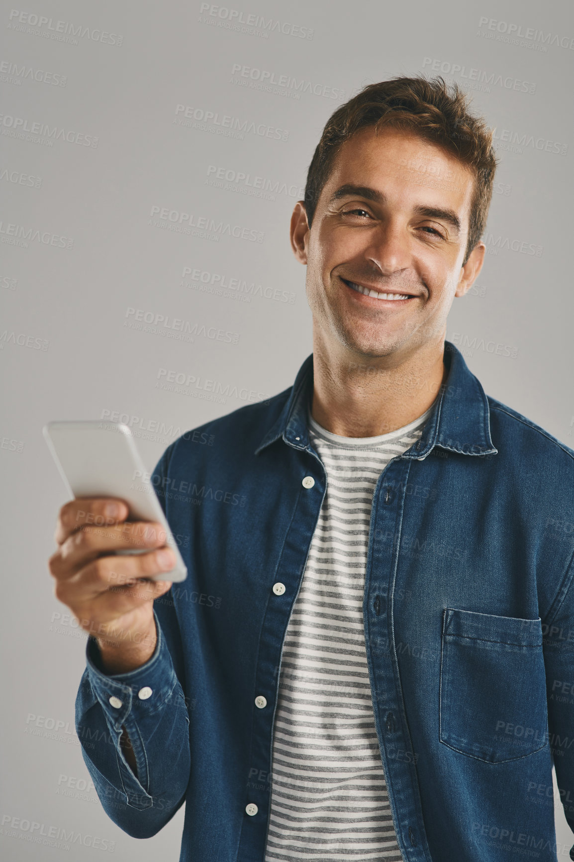 Buy stock photo Portrait, man and happy with smartphone in studio for social media, post or entertainment on white background. Male person, smile and satisfied with internet or online for communication or networking