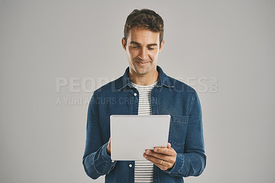 Buy stock photo Ecommerce, smile and tablet with man in studio isolated on gray background for app download or update. Search, social media and website with happy user in casual outfit for online shopping or retail