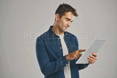 Buy stock photo Search, social media and tablet with man in studio isolated on gray background for app download or update. Ecommerce, smile and website with happy user in casual outfit for online shopping or retail