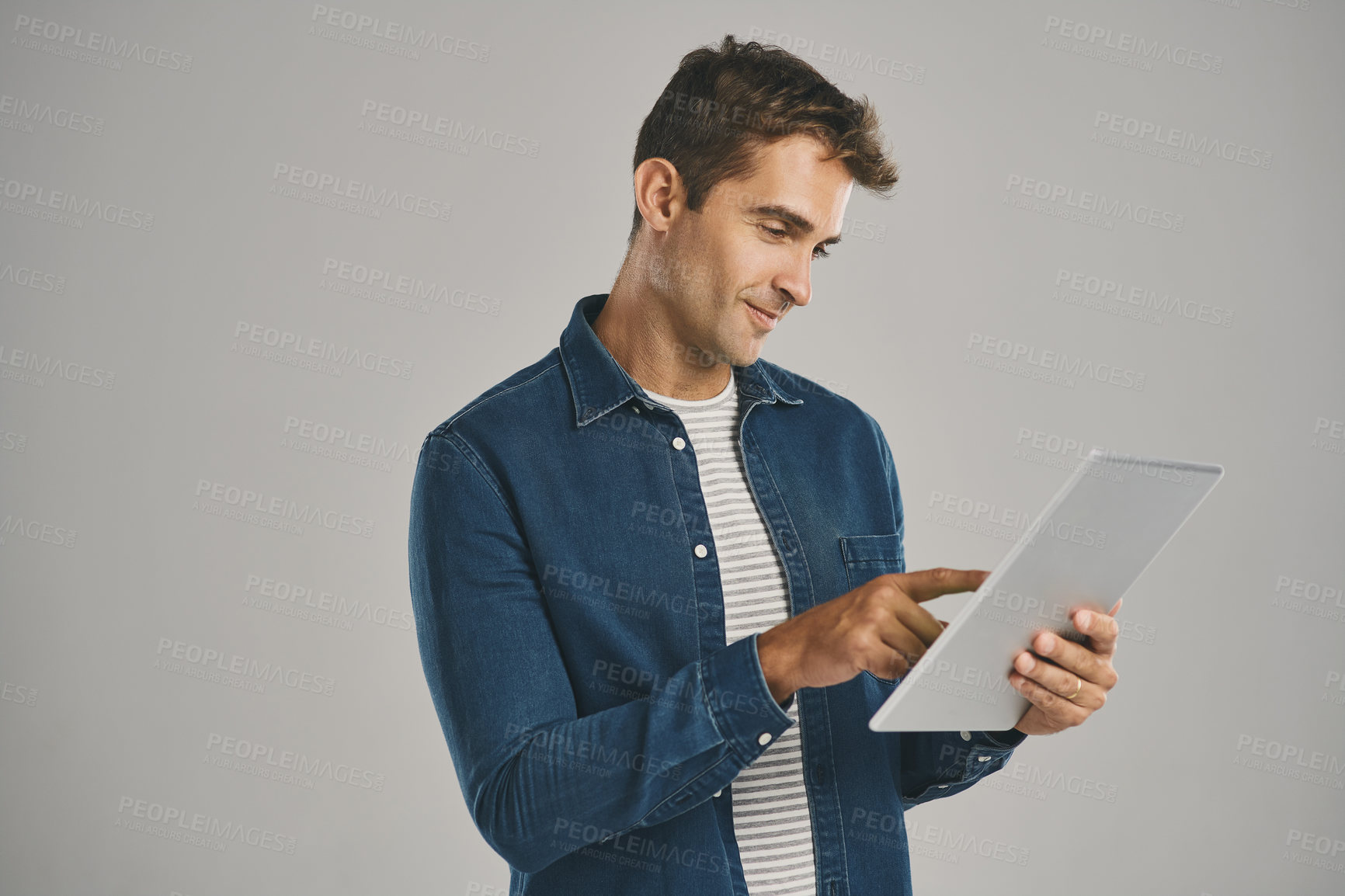 Buy stock photo Search, social media and tablet with man in studio isolated on gray background for app download or update. Ecommerce, smile and website with happy user in casual outfit for online shopping or retail