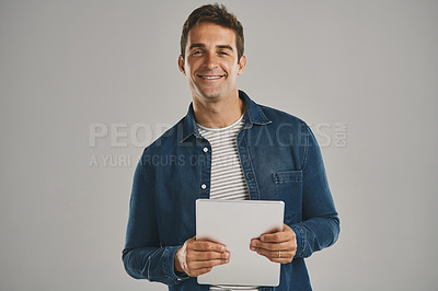 Buy stock photo Confident, portrait and tablet with man in studio isolated on gray background for app download or update. Internet, social media and technology with happy user in casual outfit for online shopping